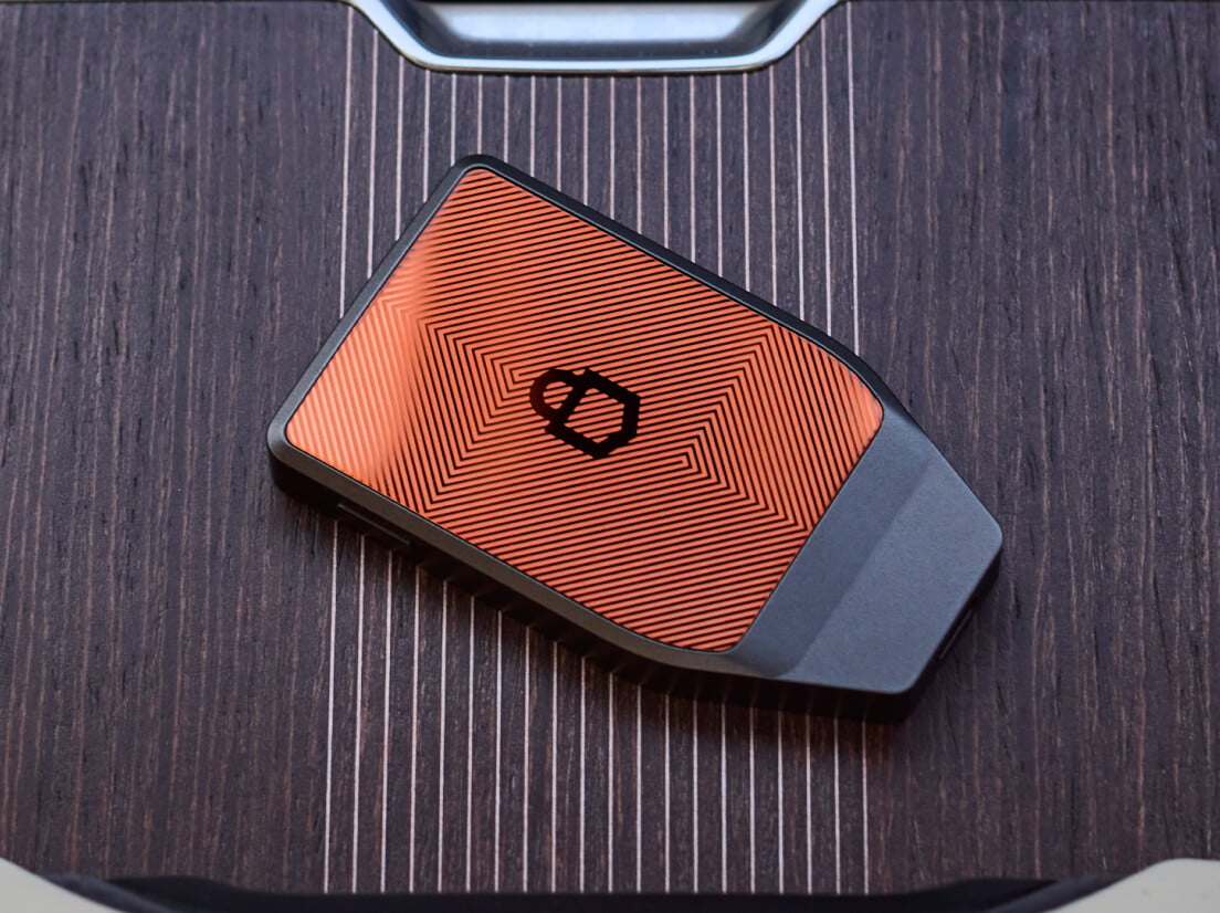 Un Trezor Safe 7 Édition Bitcoin-only sur un bureau en bois sombre, à côté d'un porte-clés avec des clés.
