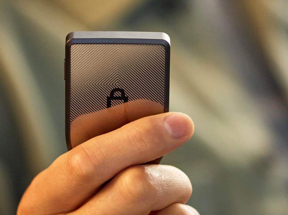 Une personne tenant un Trezor Safe 7 Noir Charbon dans sa main.