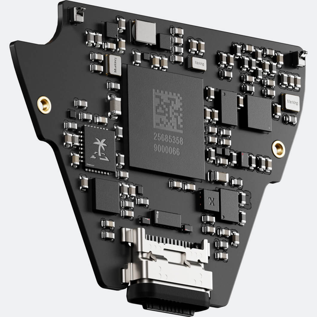 alt="A close-up, angled view of a small, black, custom-shaped circuit board featuring a large central microchip, a TROPIC01 chip with a palm tree logo, and a USB-C port at the bottom."
