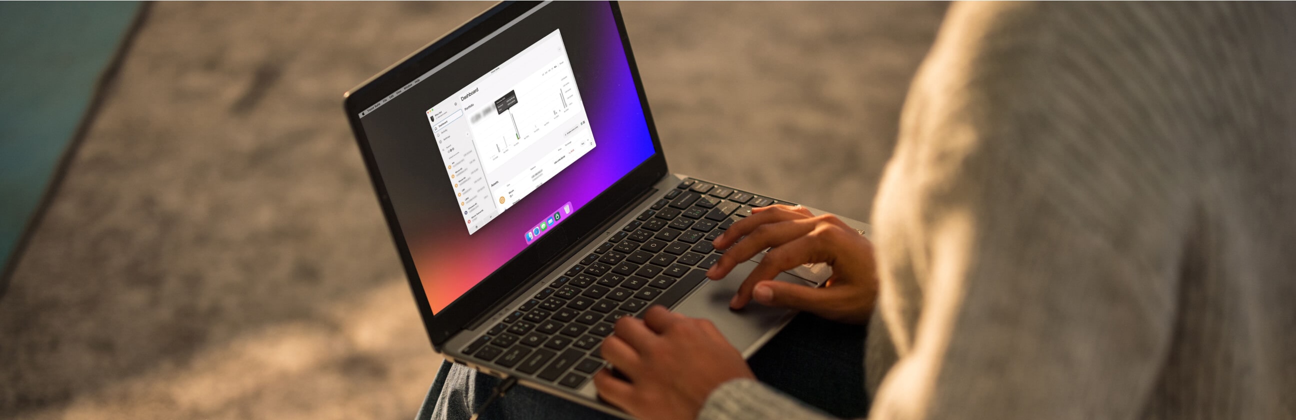 Person using the Trezor Suite app on a laptop, viewing a dashboard with cryptocurrency account details and analytics.